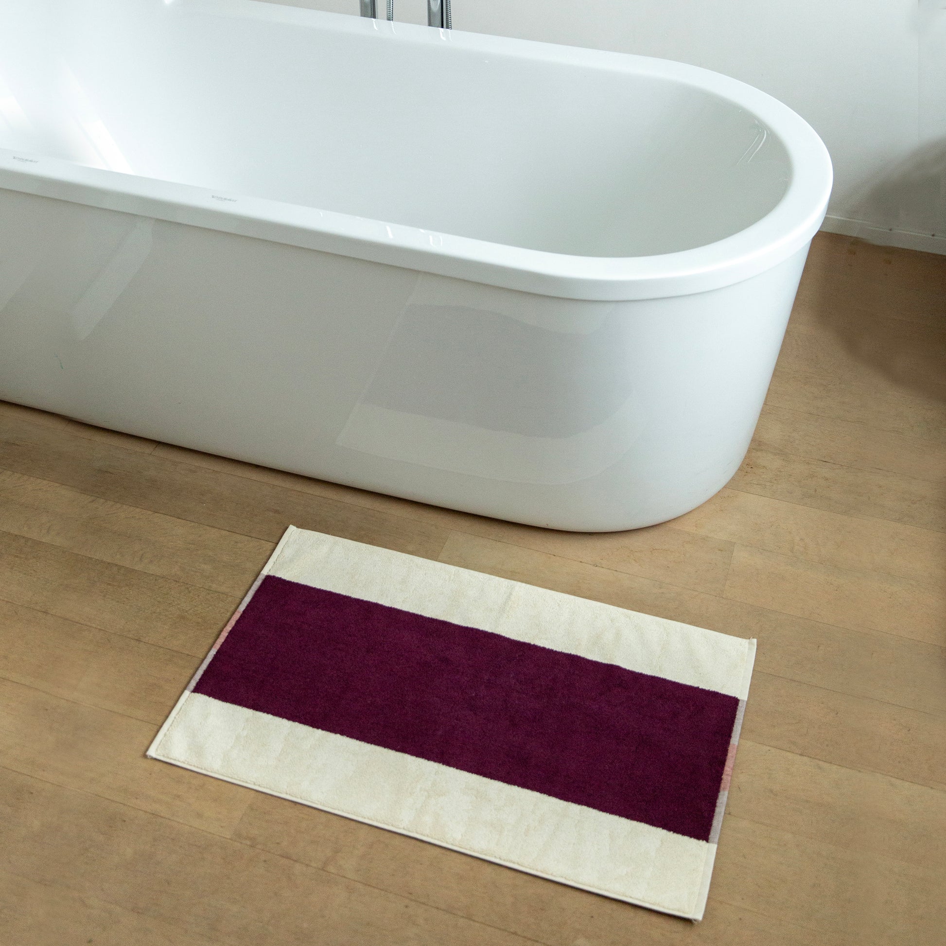 Badmat Martens & Martens Bordeaux&Orange│Suite702│art. MMBM50BOOR│op houten vloer naast bad