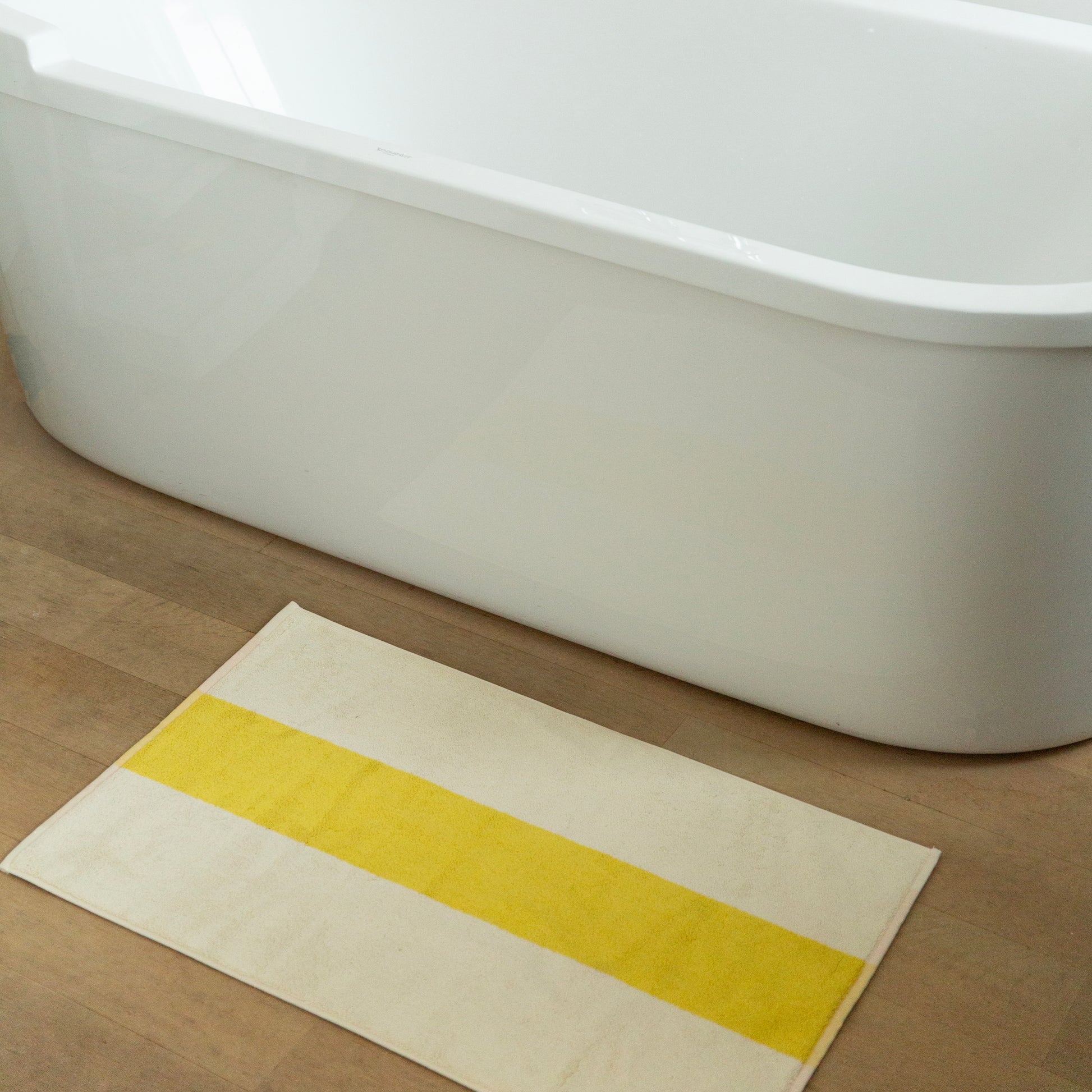 Badmat Martens&Martens Yellow&Peach│Suite702│art. MMBM50YEPE│op houten vloer naast bad