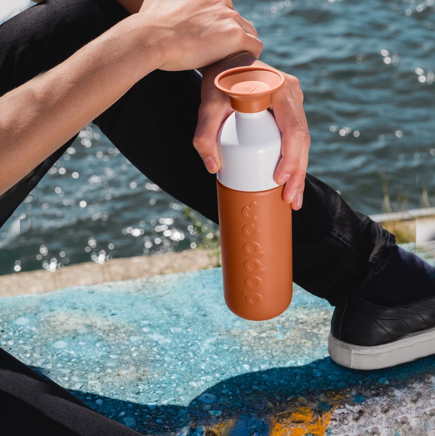 Dopper Insulated Large Terracotta Tide│Thermosfles 580ml Roodbruin│art. 3384│zitte mmet fles in hand op kade