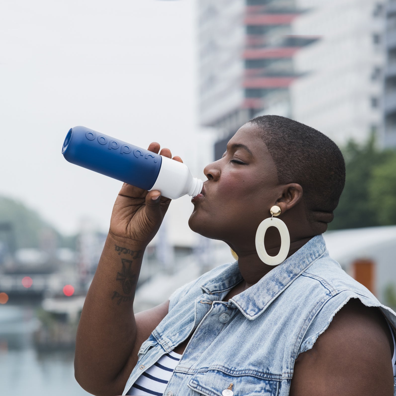 Dopper Original Cosmic Storm│Waterfles 450ml Blauw│art. 3810│vrouw drink water uit fles met std op achtergrond