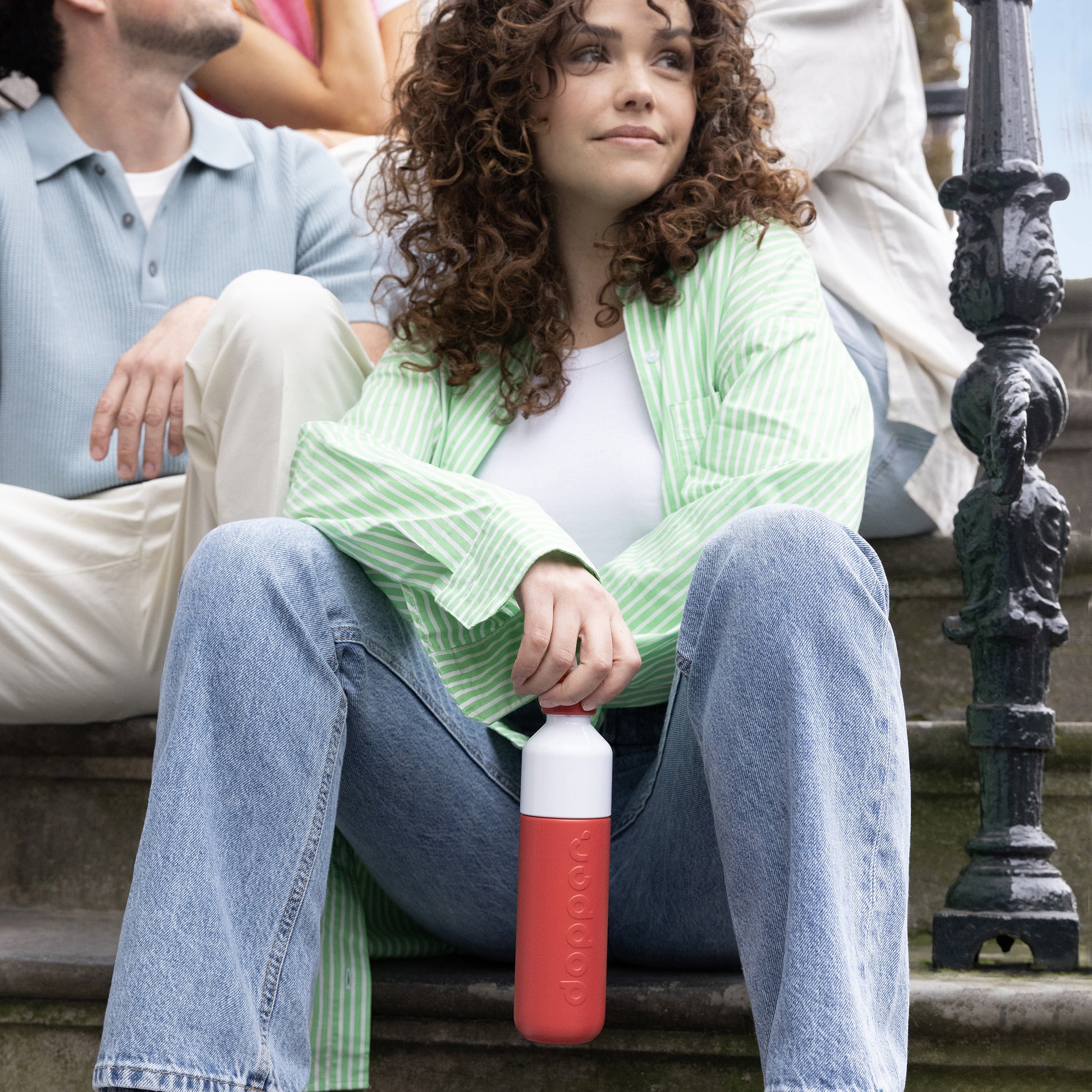 Dopper Insulated Small Deep Coral│Thermosfles 350ml Rood│art. 5272│vrouw op trap met fles in hand