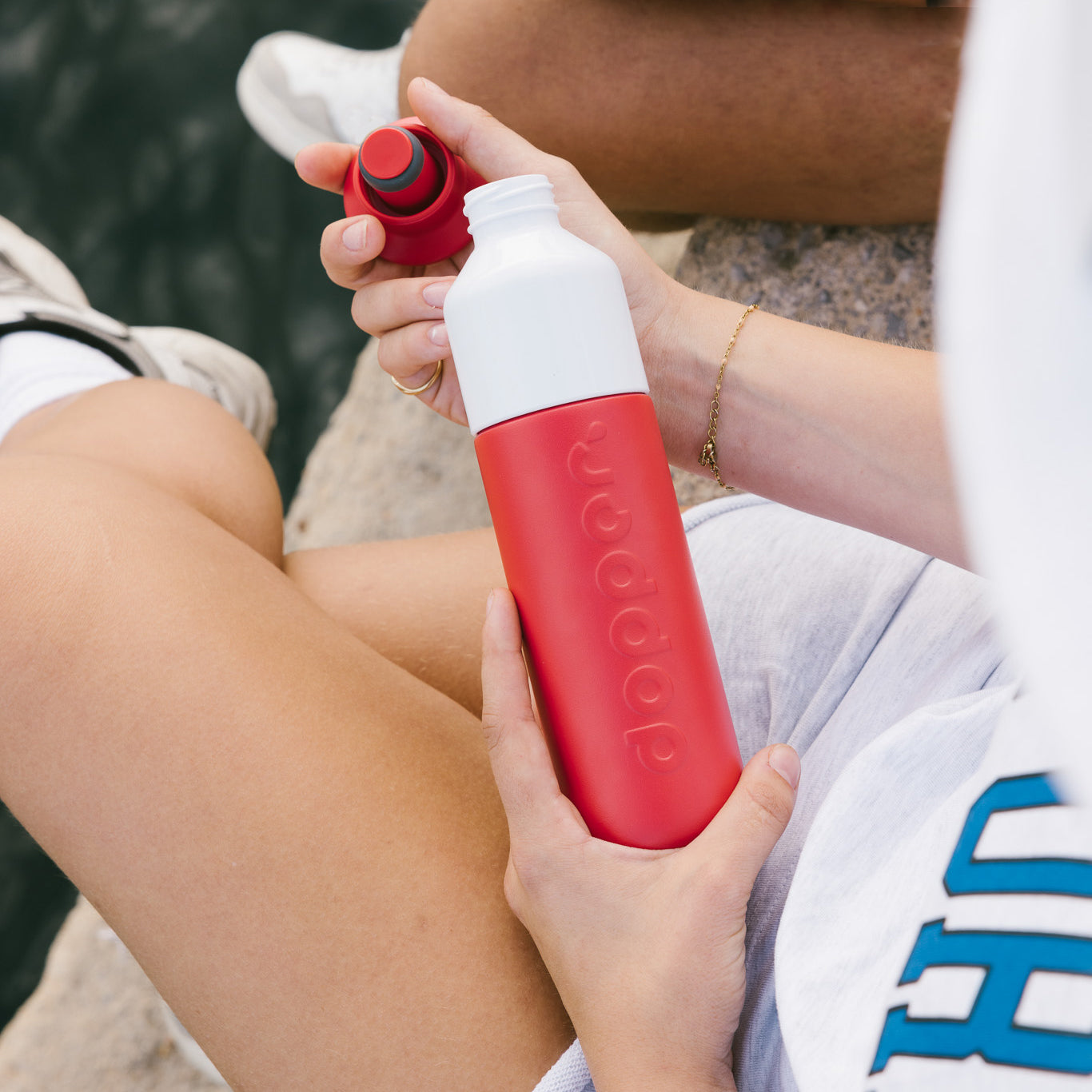 Dopper Insulated Small Deep Coral│Thermosfles 350ml Rood│art. 5272│aan waterkant met fles in hand