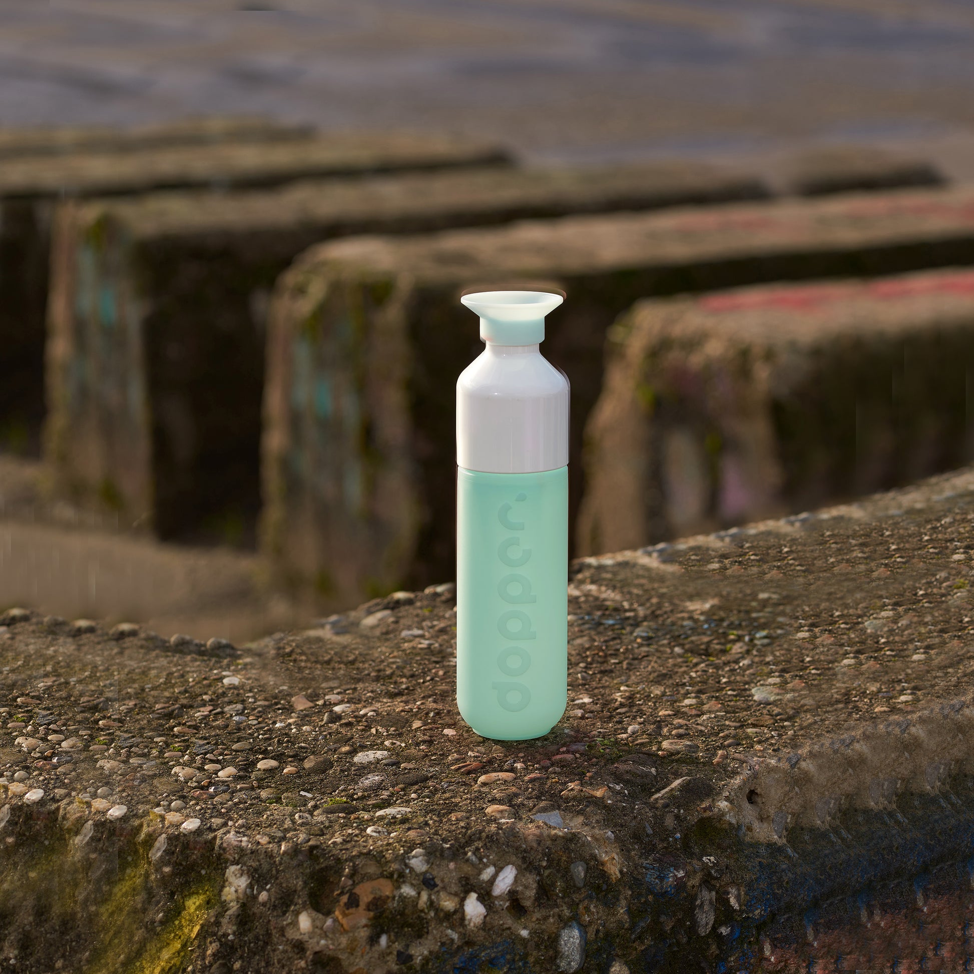 Dopper Original Polar Blue│Waterfles 450ml Lichtblauw│art. 5180│op betonen rand naast zee