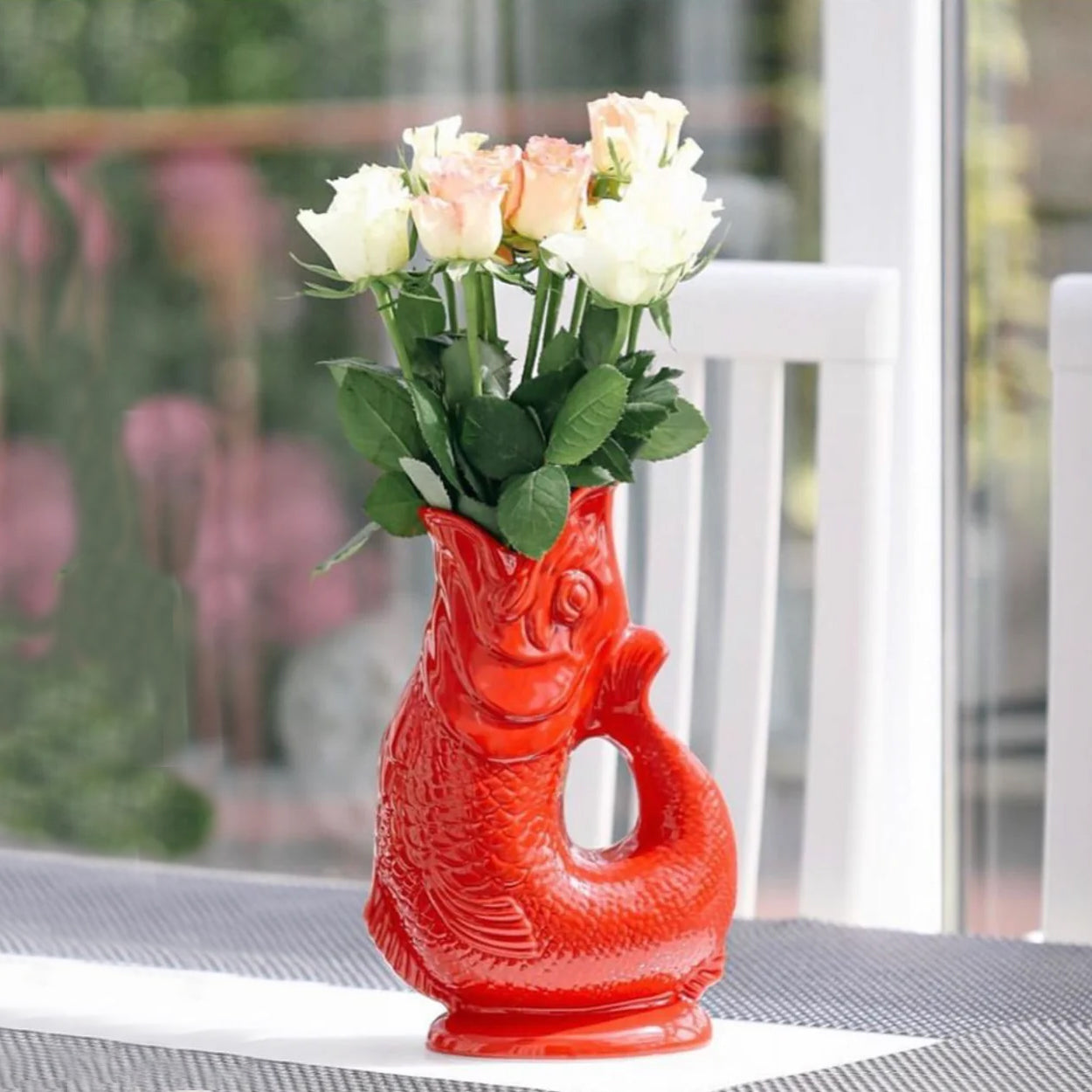Gluckigluck Waterkaraf Vis│Rood│Guggle Jug│art. G31155/R/W│op terrastafel met bloemen