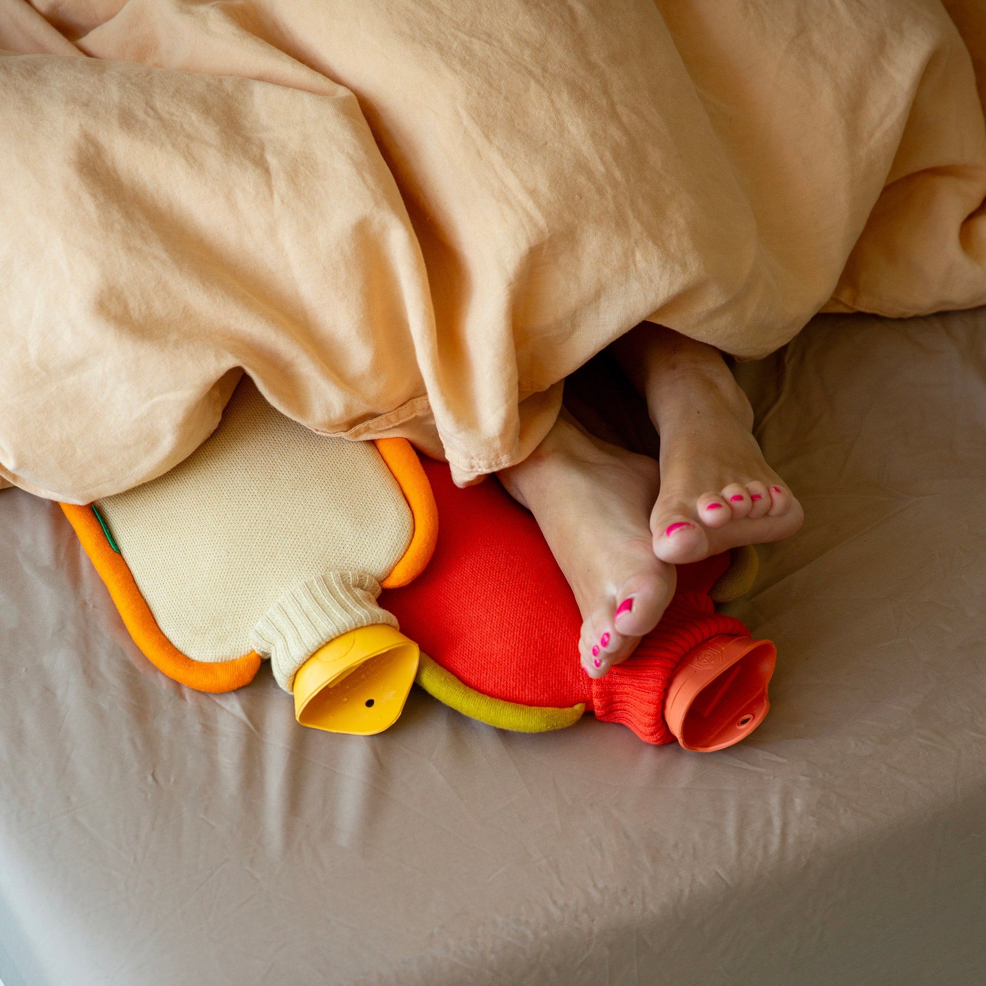 Warmwaterkruik Katoen Bumper Poppy Orange│Suite702│art. BHWBPO│met blote voeten onder deken op kruik