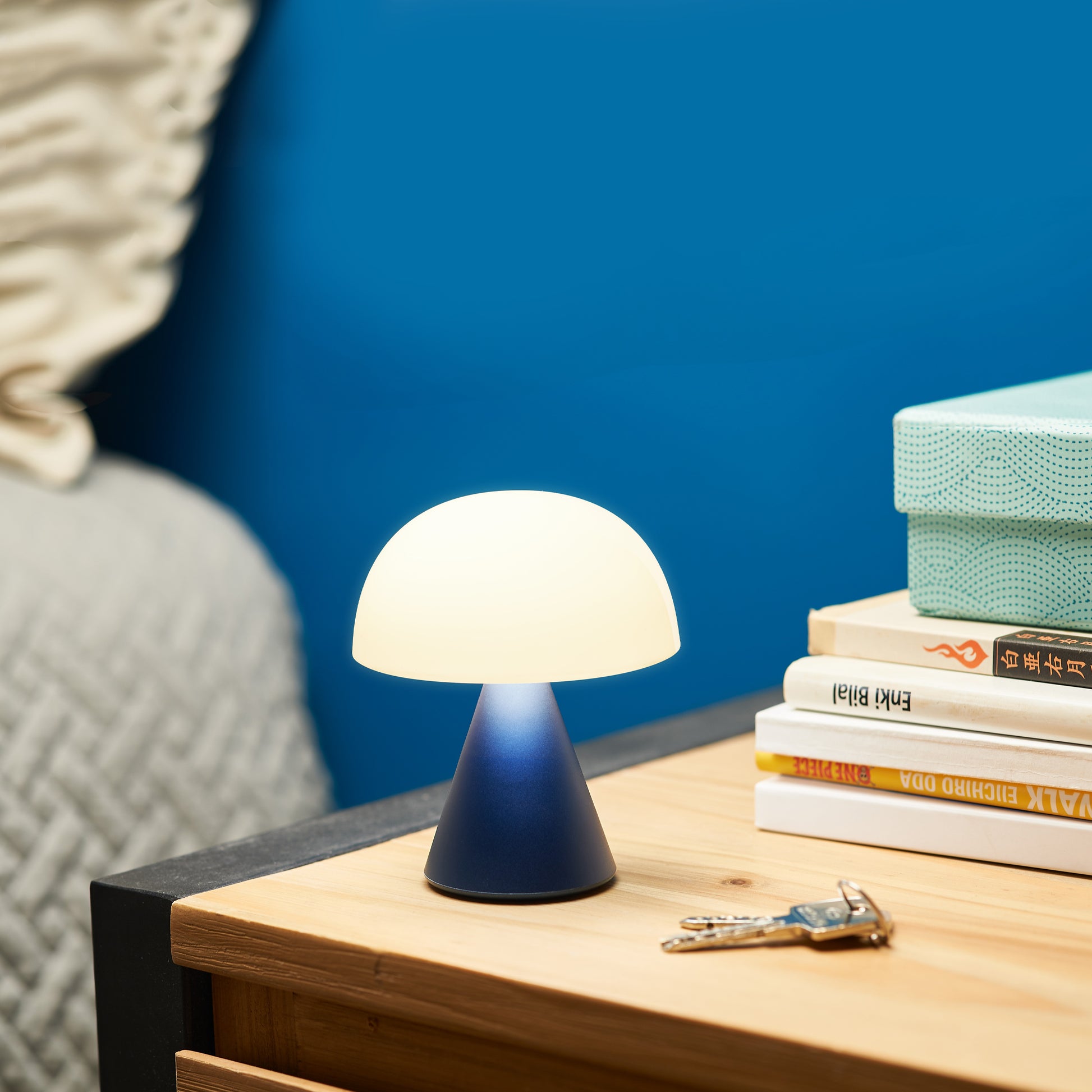Lexon Mina Medium Donkerblauw│Oplaadbare LED-lamp│art. LH64MDB│op nachtkastje naast sleutels en boeken