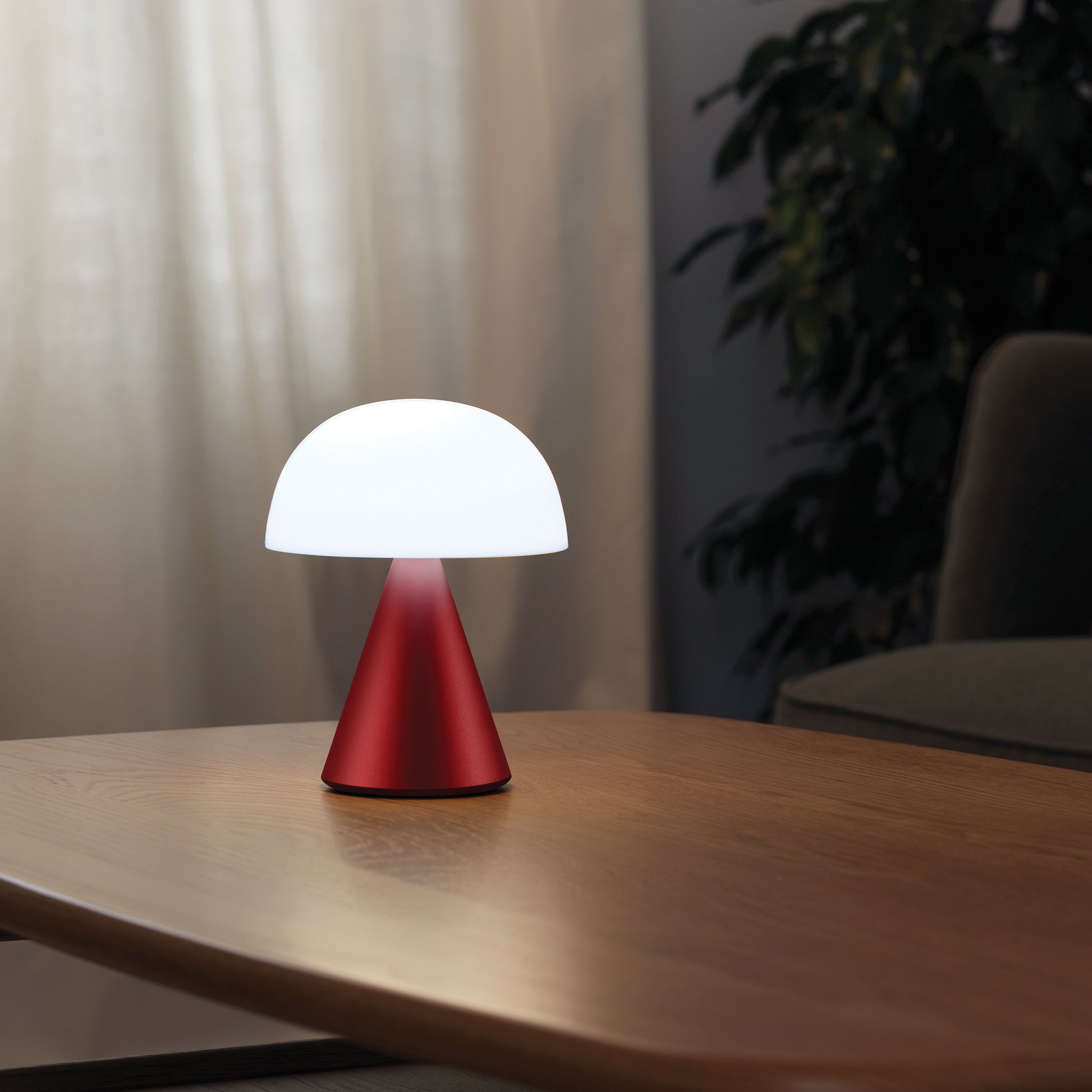 Lexon Mina Large Oplaadbare Tafellamp Donkerrood│art. LH65DR│op salontafel met wit licht aan