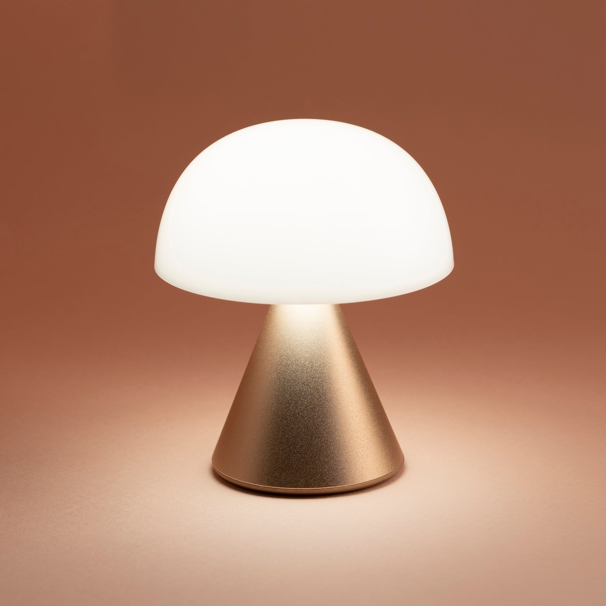 Lexon Mina Small Soft Gold│Oplaadbare LED lamp│art. LH60MD│vooraanzicht met gele achtergrond