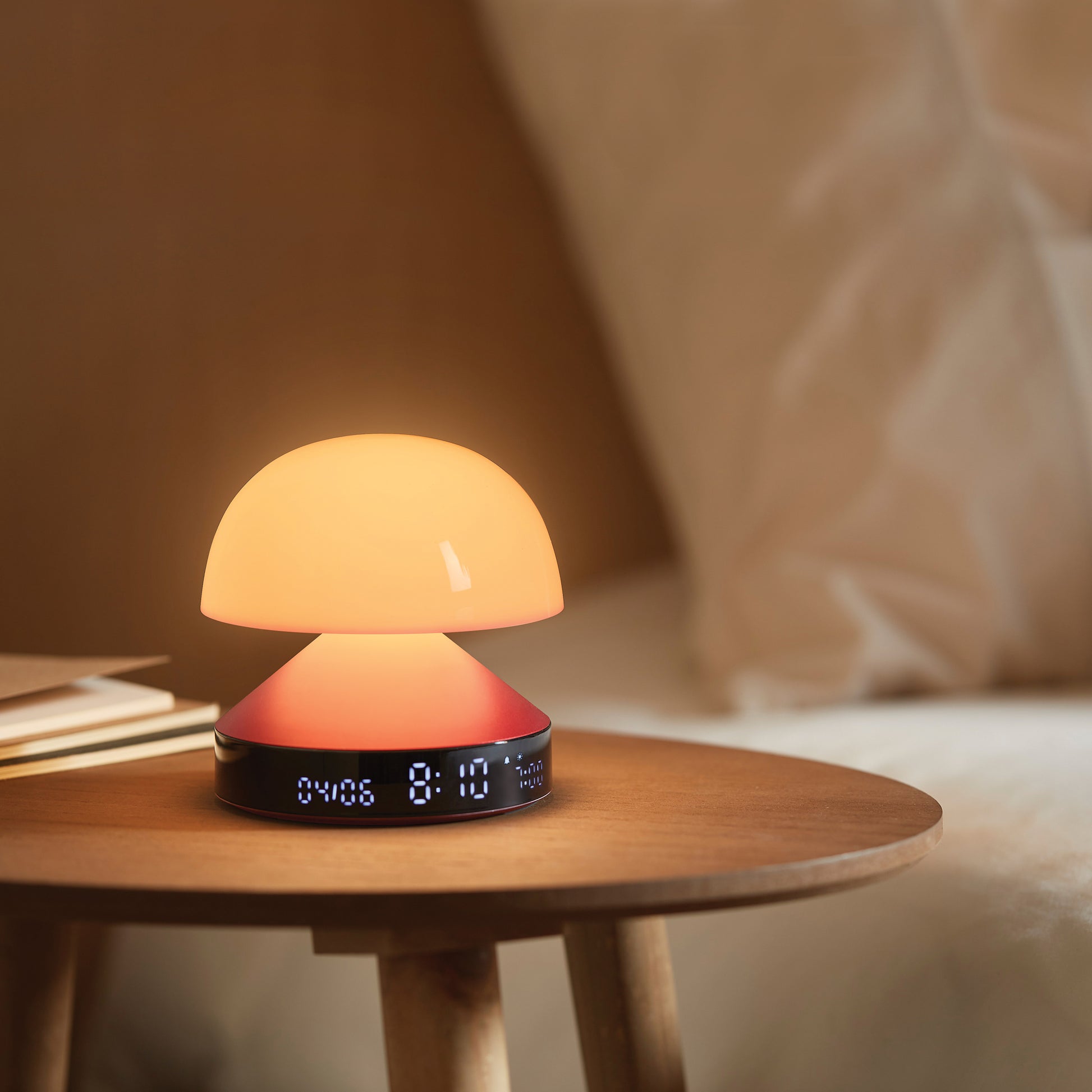 Lexon Mina Sunrise Wekker Donkerrood│Wake-up Light│art. LR153DR│op houten tafeltje naast bed met licht aan