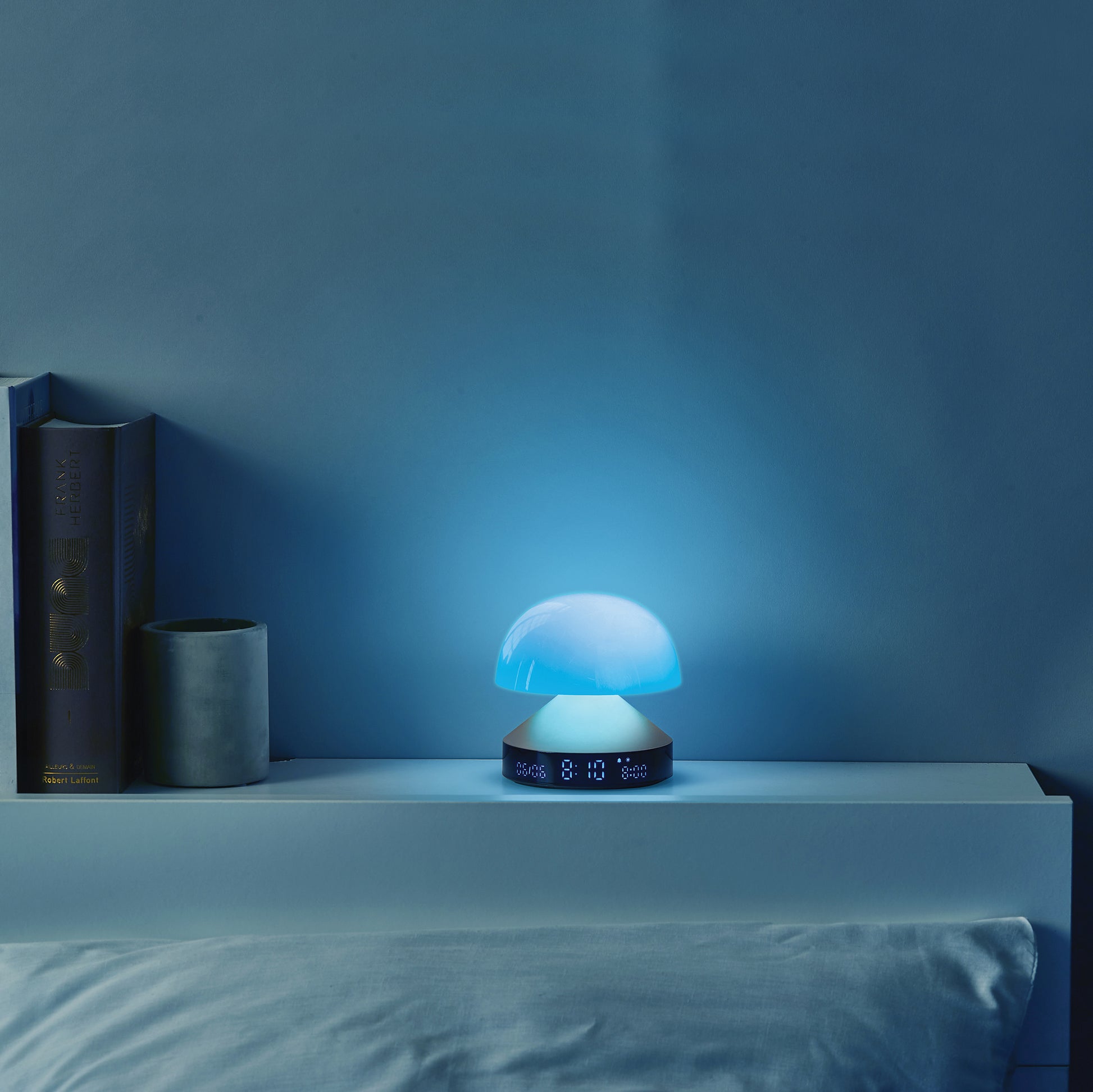 Lexon Mina Sunrise Gun Wekker│art. LR153MX│op rand boven bed met blauw licht aan