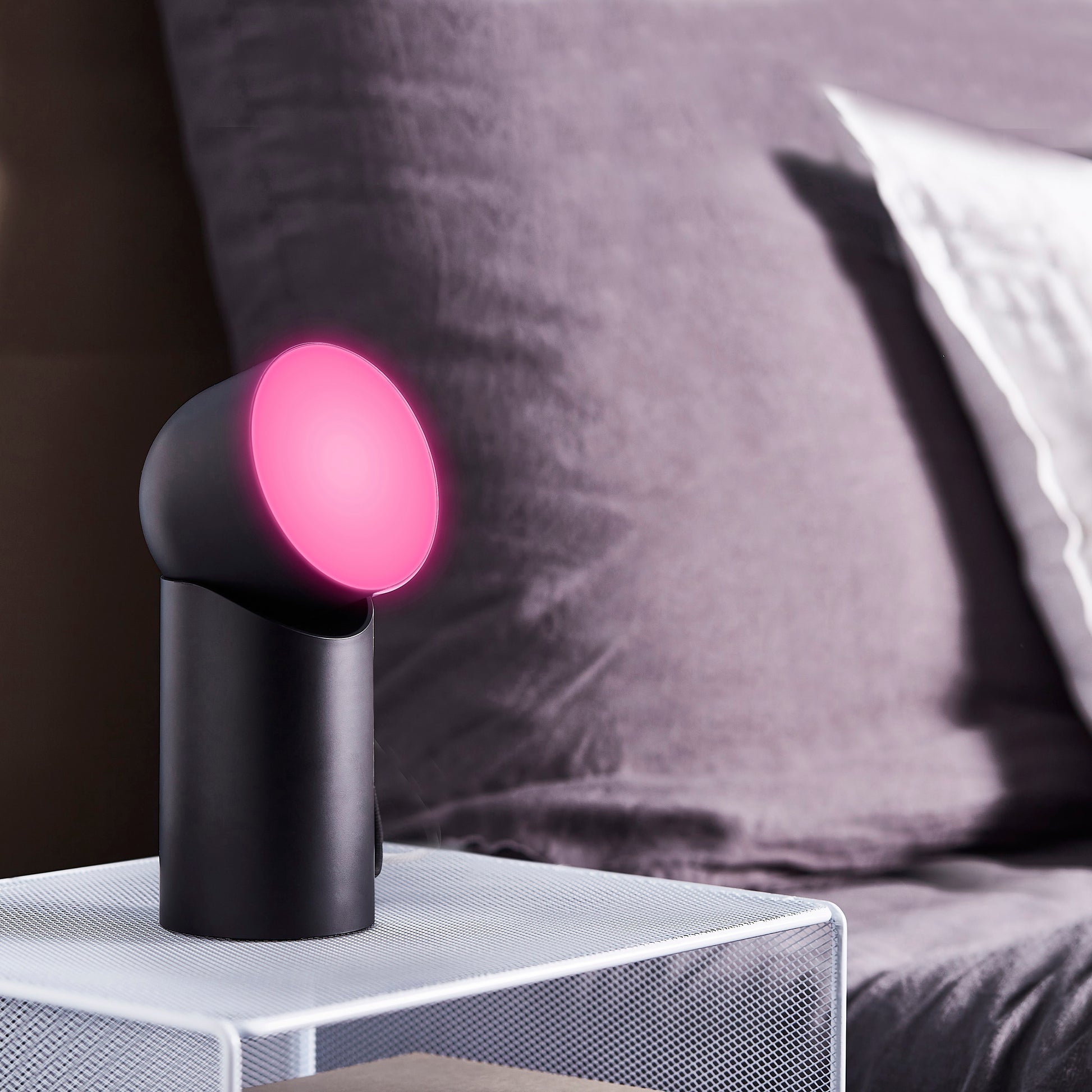 Lexon Orbe Zwart│Oplaadbare Tafellamp│art. LH88N│op nachtkastje met roze licht naar boven gericht
