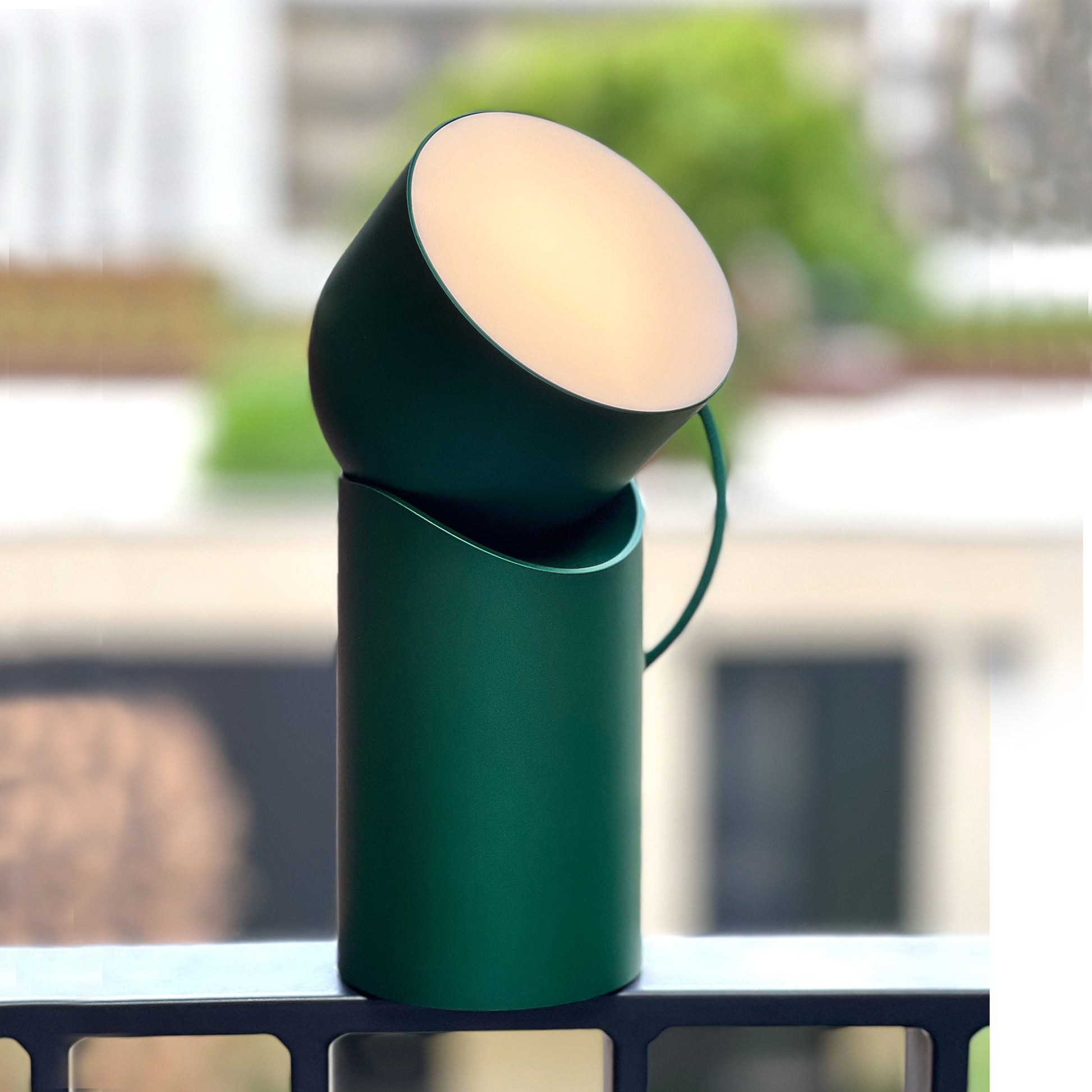 Lexon Orbe Donkergroen│Oplaadbare Tafellamp│art. LH88DG1│op railing vensterbank met warm licht aan