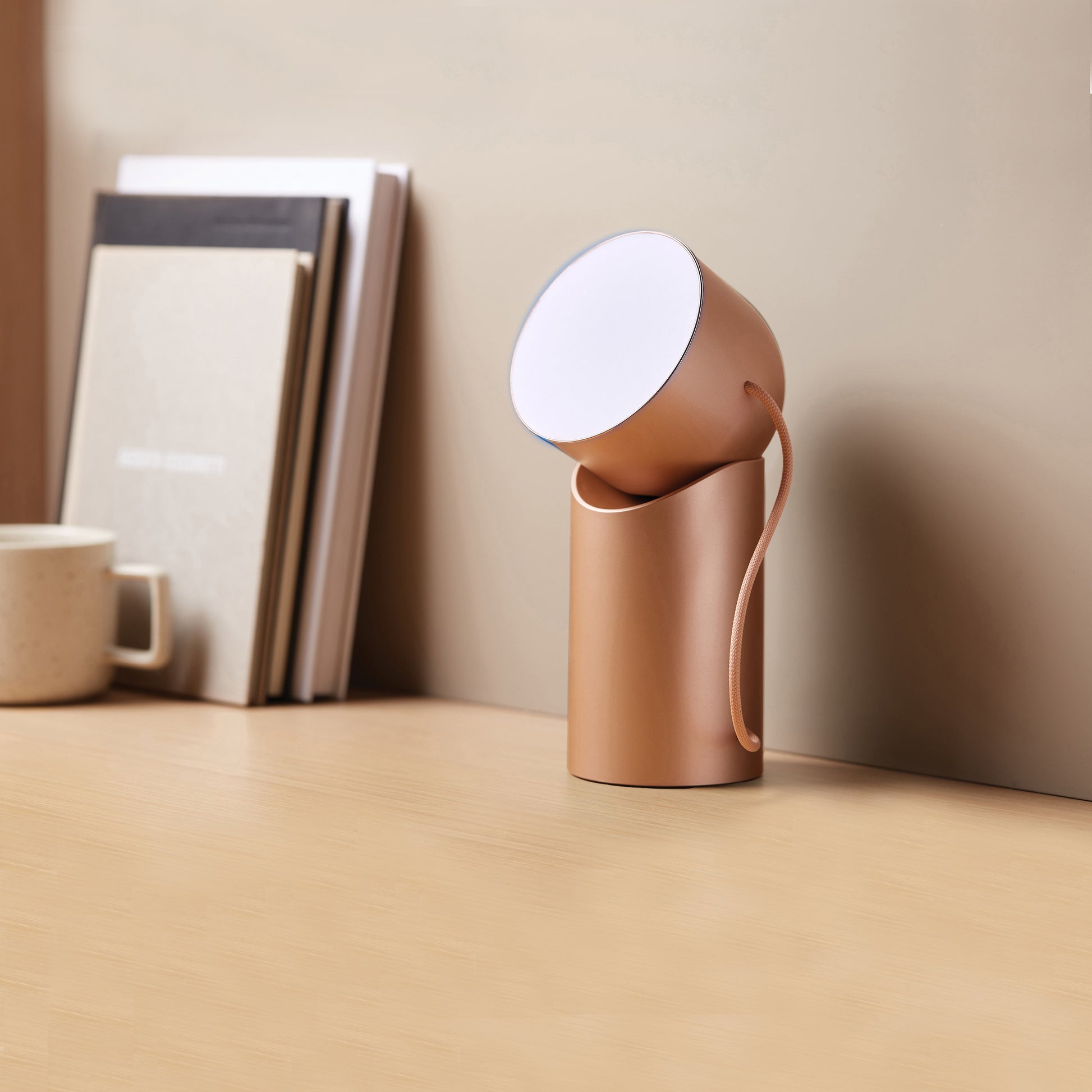 Lexon Orbe Goud│ Oplaadbare Tafellamp│art. LH88D│op bureau met wit licht aan