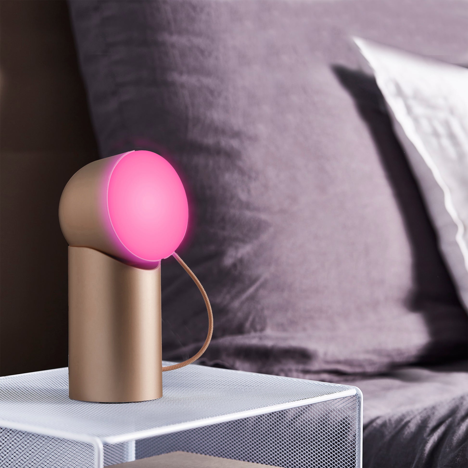 Lexon Orbe Goud│ Oplaadbare Tafellamp│art. LH88D│op nacht kastje met magenta licht aan