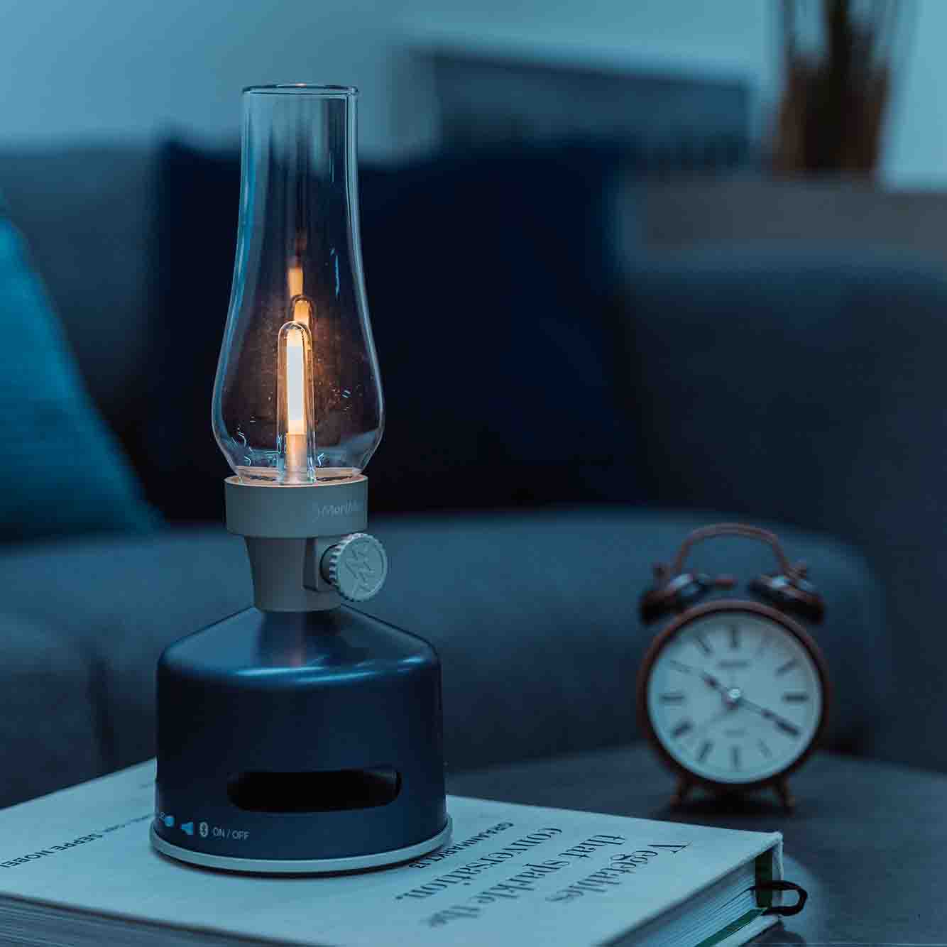 MoriMori Led Lantern & Bluetooth Speaker Moonlit Ocean Navy│Buitenverlichting│art. FLS-2010-SN│in schemering op boek met licht gedimt aan