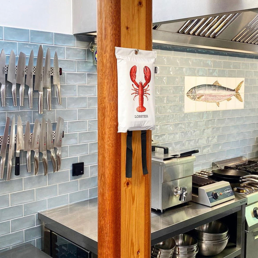 Blusdeken Kreeft Naais│Fire Blanket│art. FB01LOB│in resturant keuken op houten balk