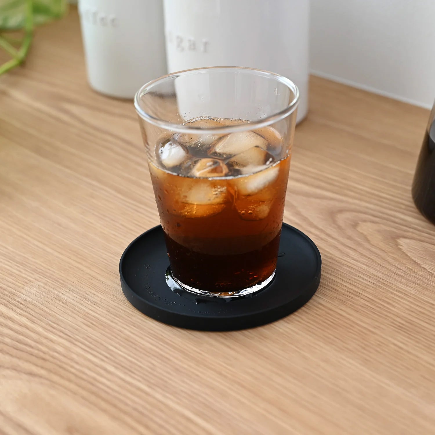 Tower onderzetter Siliconen Zwart│Yamazaki│art. 025393│o p houten blad met glas met cola