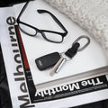 Orbitkey Clip V2 Silver│art. CLPL-2-SVBKBK│naast bril op stapel boeken