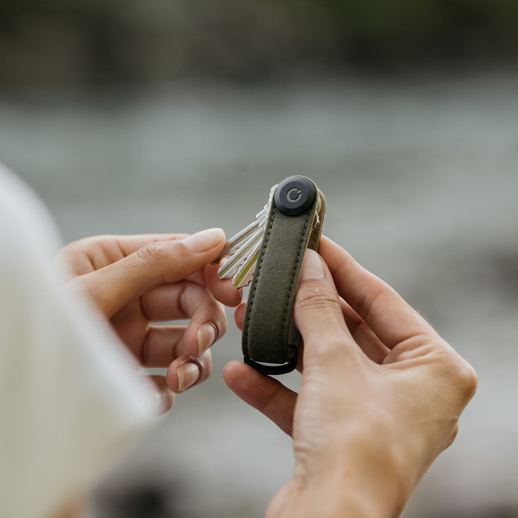 Orbitkey Waxed Canvas Sleutelhouder Khaki Green│art. KWC2-KGN-107│vrouw vouwt sleutels uit Key Organiser