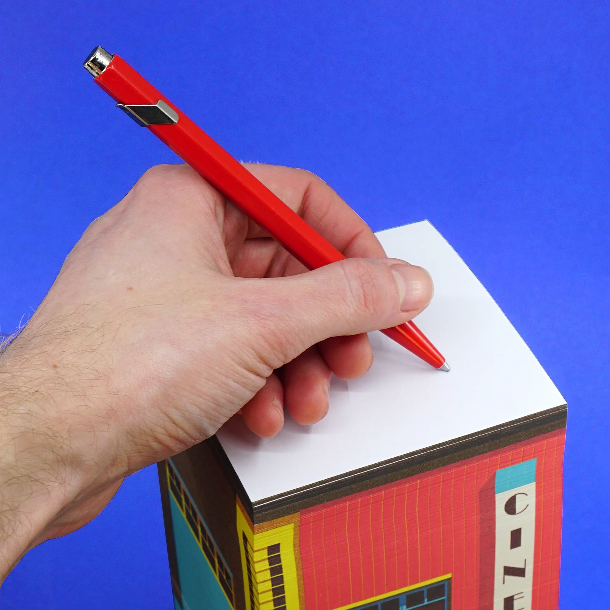 Paperscraper Cinema│Memoblok│hand met pen op bovenste pagina