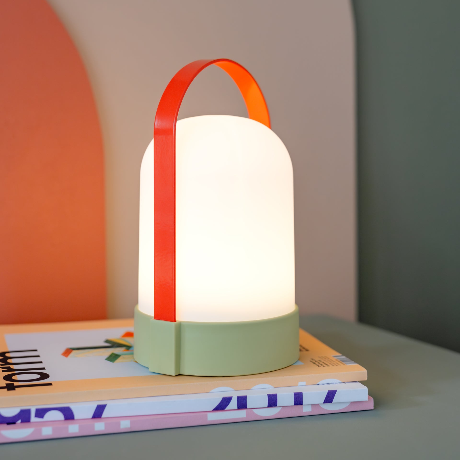 Uri Juna Oplaadbare Tafellamp│Remember│art. LU08│op stapel tijdschriften met licht aan