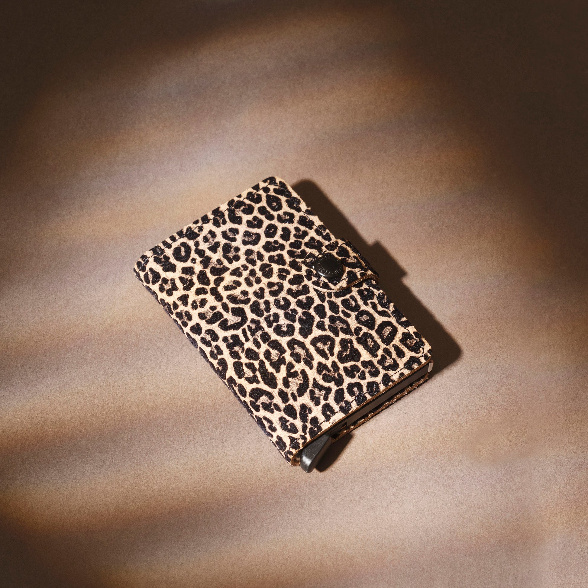 Secrid Miniwallet Leo│art. MLE-BEIGE│Pasjeshouder en Portemonnee│liggend op beige ondergrond met schaduw