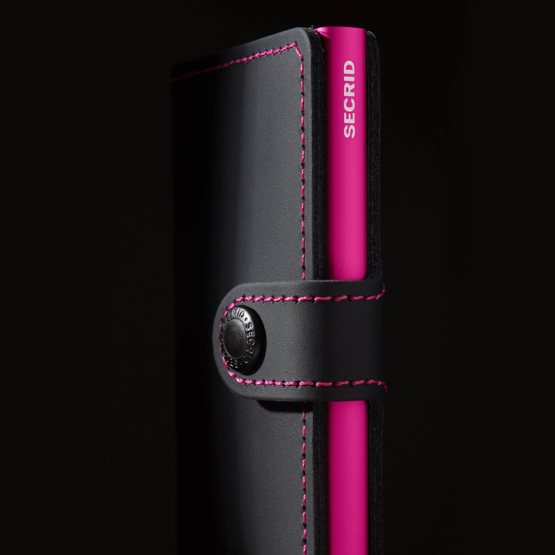 Secrid Miniwallet Matte│art. MM-BLACK&FUCHSIA│Pasjeshouder en Portemonnee│zijkant schuin met schaduw en zwarte achtergrond