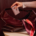 Secrid Miniwallet Pebble│Pasjeshouder│art. MPE-ROSE│in hand van vrouw boven tas