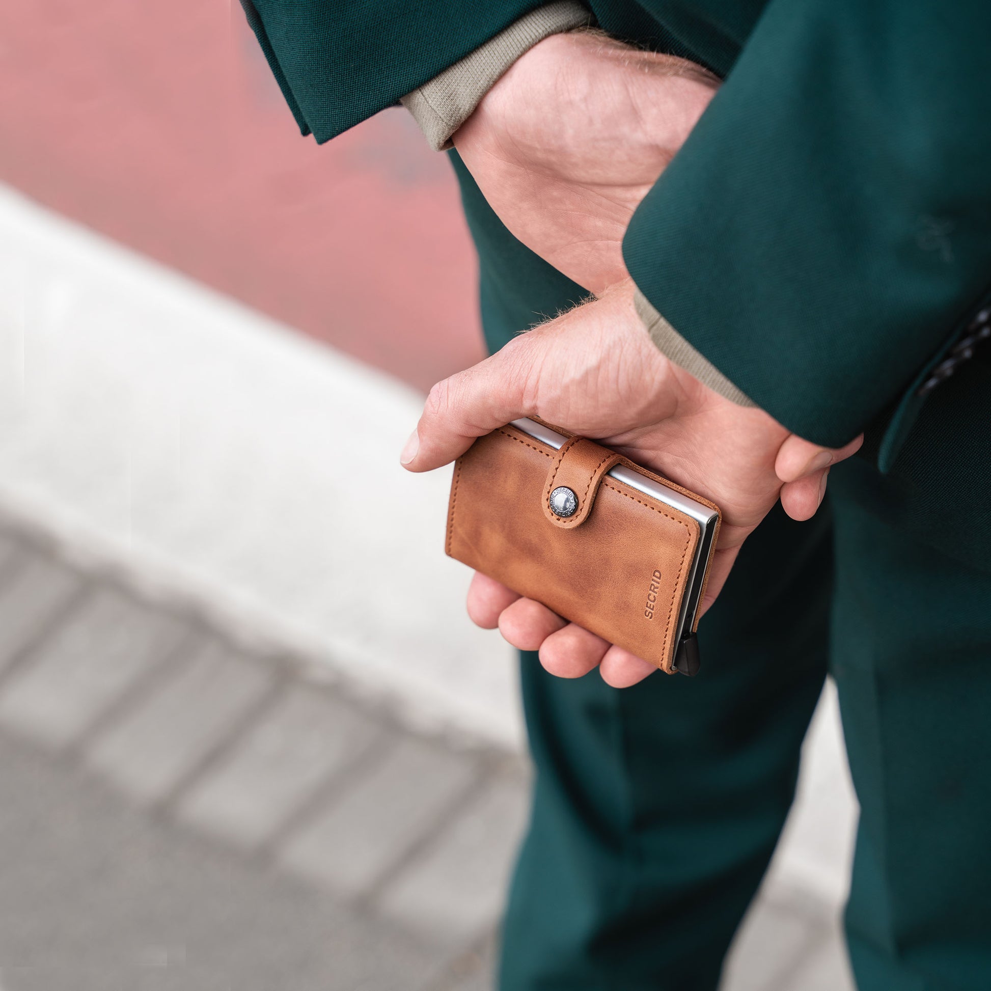 Secrid Miniwallet Vintage│art. MV-COGNAC&SILVER│Pasjeshouder en Portemonnee│in handen op rug van man