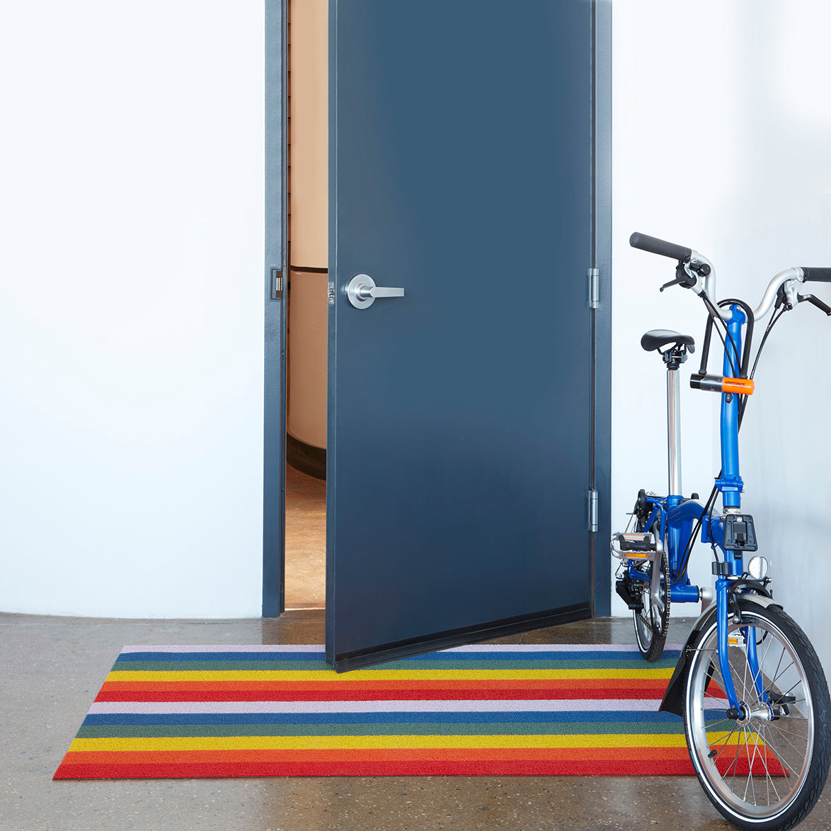 Chilewich Shag Deurmat 46x71 Pride Rainbow│art. 200872-001│in hal met blauwe fiets