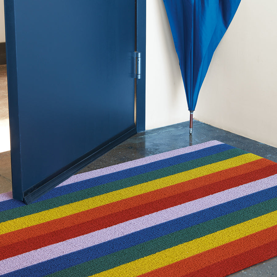 Chilewich Shag Deurmat 46x71 Pride Rainbow│art. 200872-001│in hal naast blauwe deur en paraplu