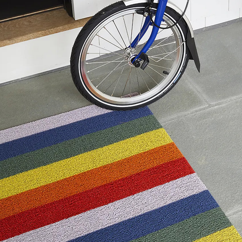 Chilewich Shag Deurmat 46x71 Pride Rainbow│art. 200872-001│close-up op tegelvloer naast fiets