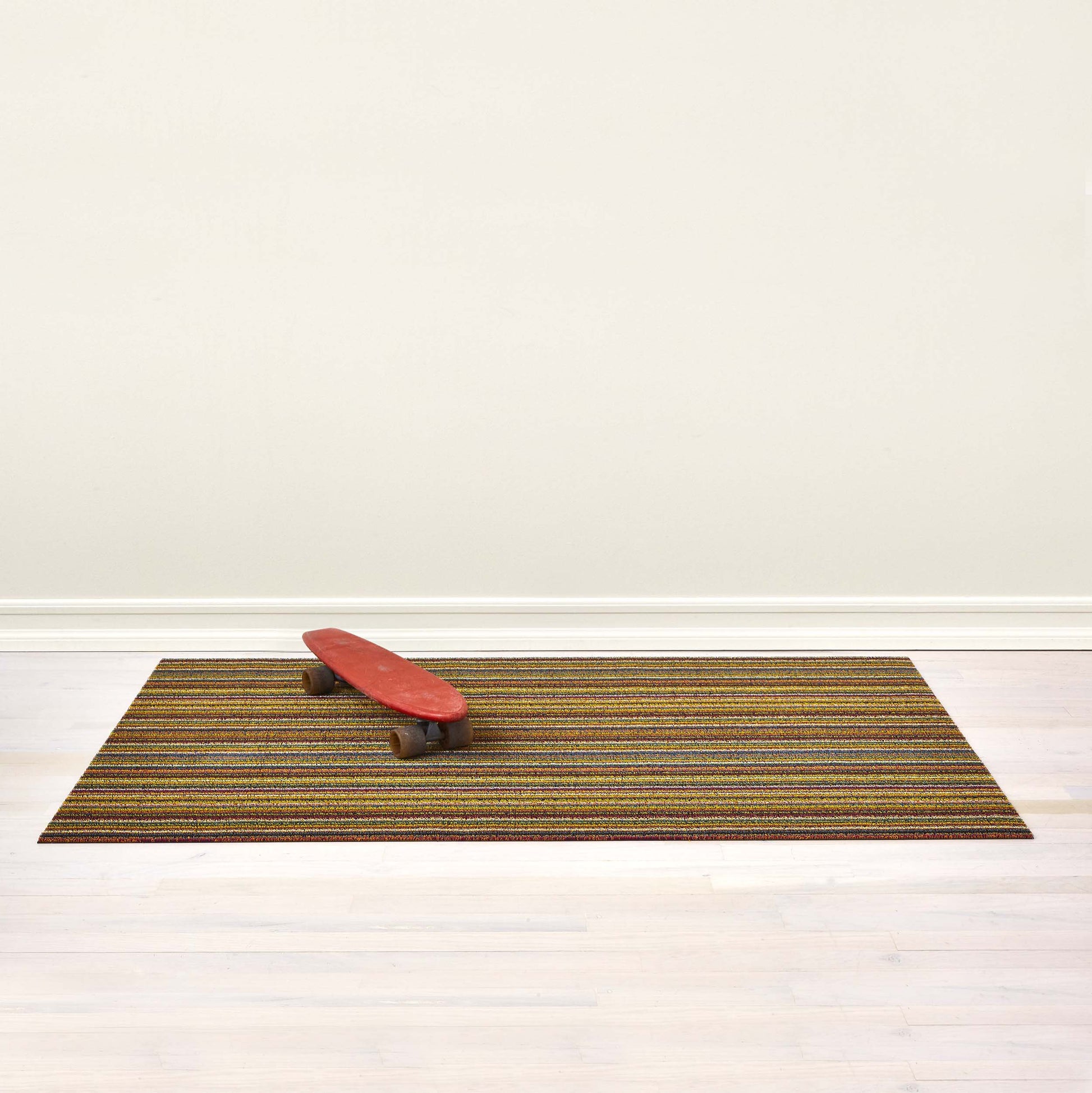 Shag Deurmat 46x71 Skinny Stripe Bright Multi│art. 200134-002│met skateboard op houten vloer