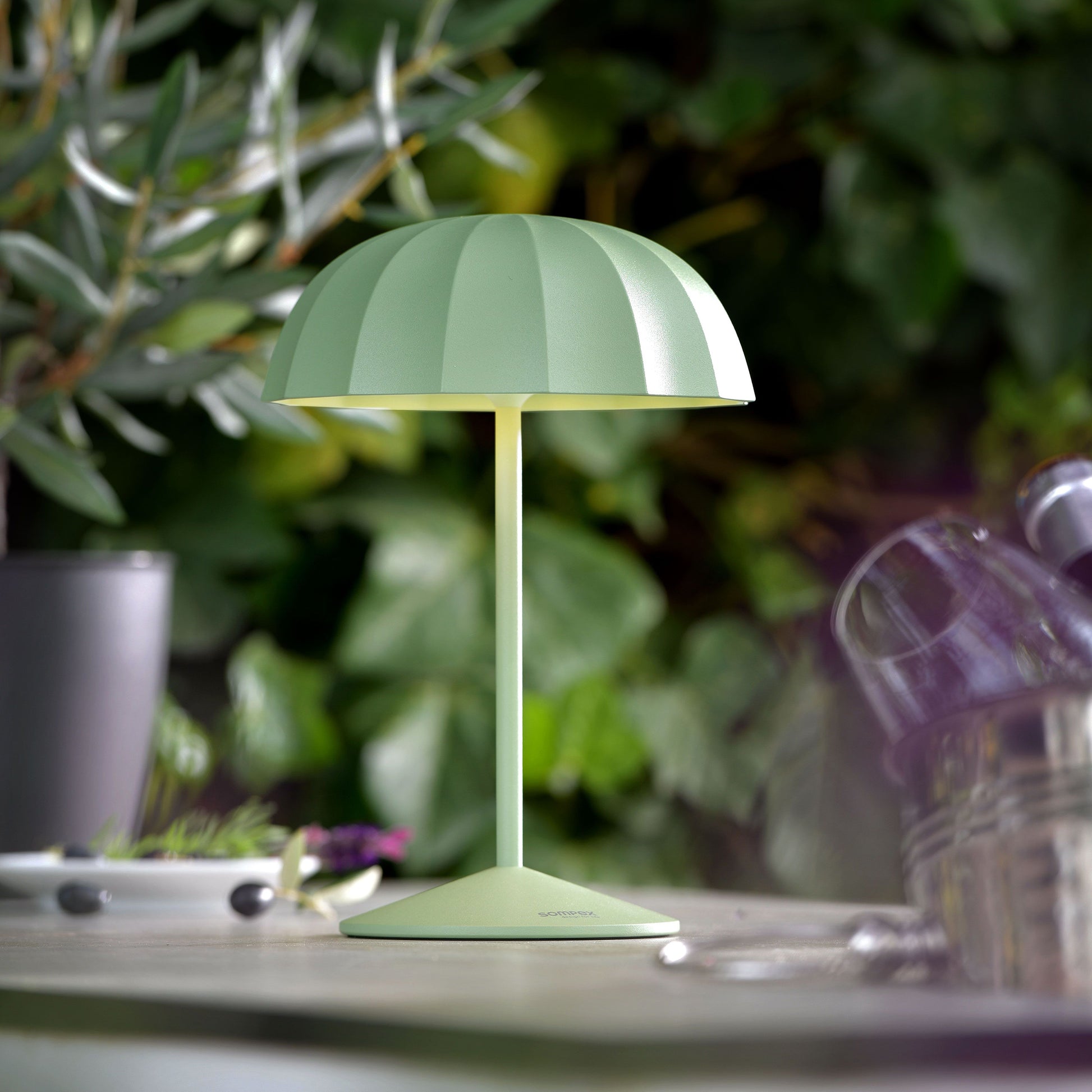 Sompex Ombrellino Oplaadbare Buitenlamp│Oliv│art. 78355│op buitentafel met planten op achtergrond