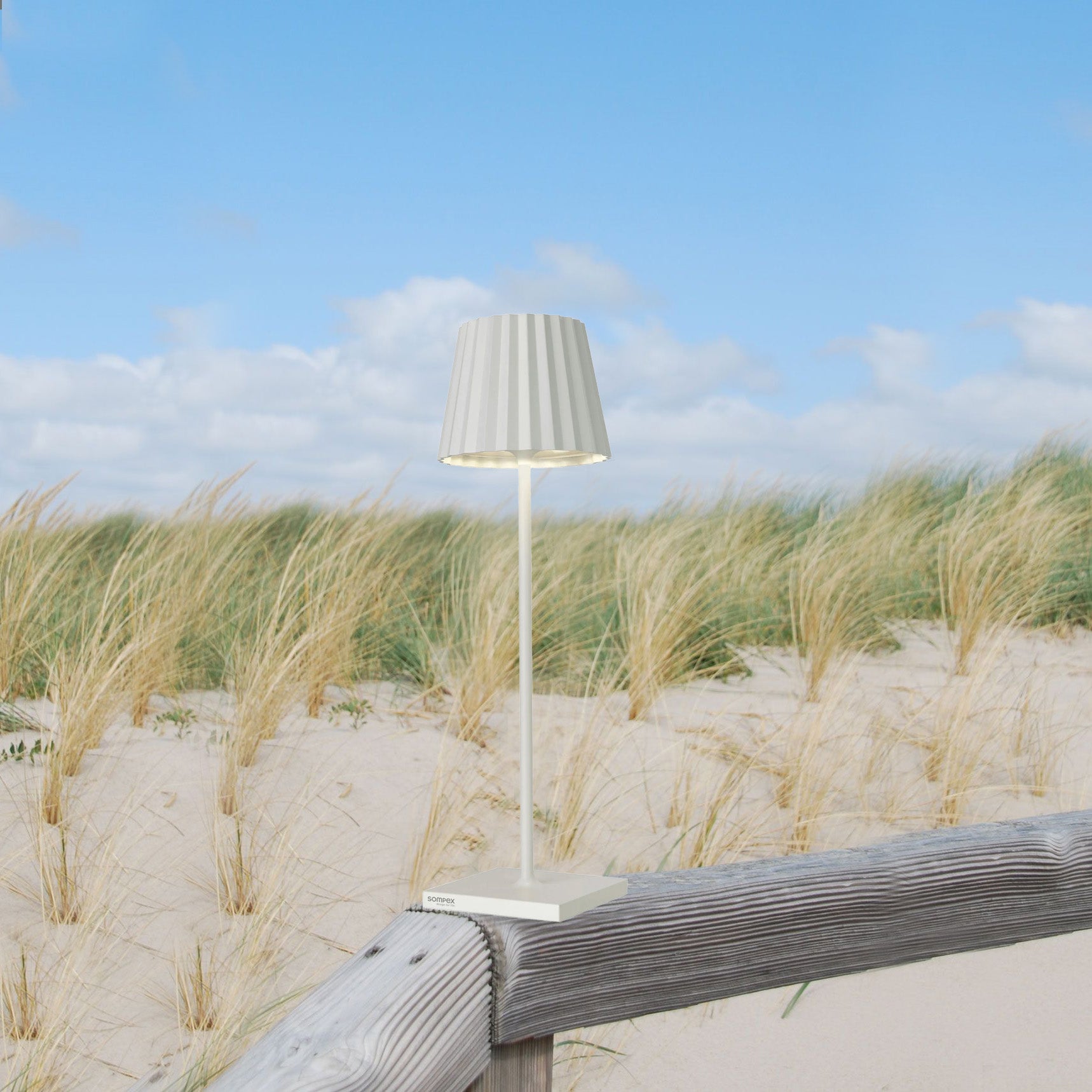 Sompex Troll 2.0 Wit│Oplaadbare Tafellamp│Buitenverlichting│art. 78170│op houten hek in duinen