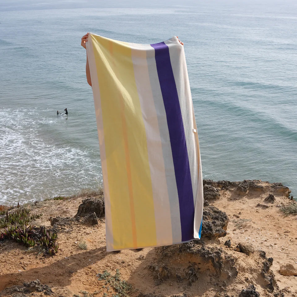 Strandlaken Martens & Martens Aqua Orange Purple & Yellow Suite702│art. CMMTT90AQORPUYE│achterkant vastgehouden op strand