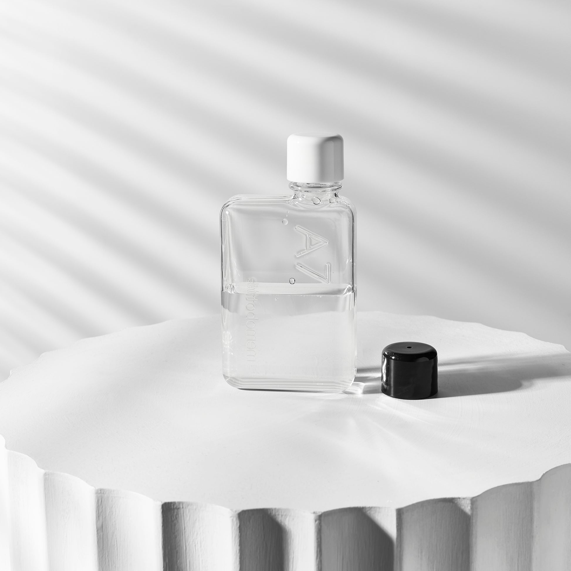 Memobottle A7│Platte Waterfles 180ml│foto op rond blok met witte en zwarte dop