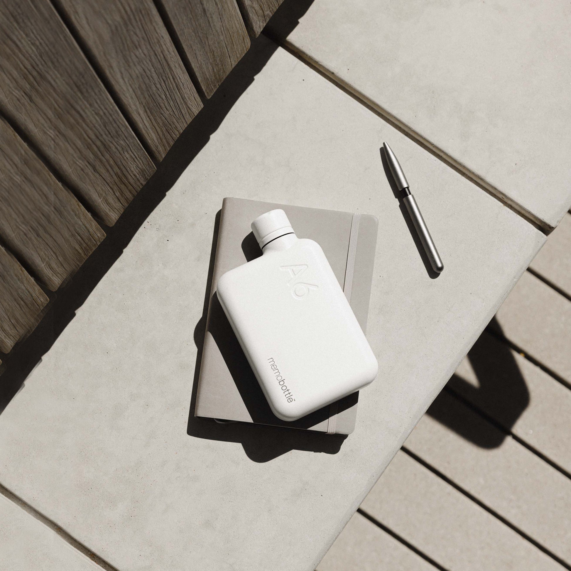 Memobottle Stainless Staal A6 Wit│Drinkfles│foto op bank met notebook en pen