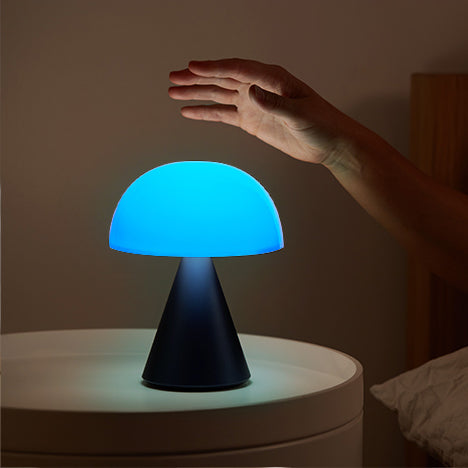 Lexon Mina large Oplaadbare Tafellamp Donkerblauw│LH65MDB│op nachtkastje met blauw licht aan