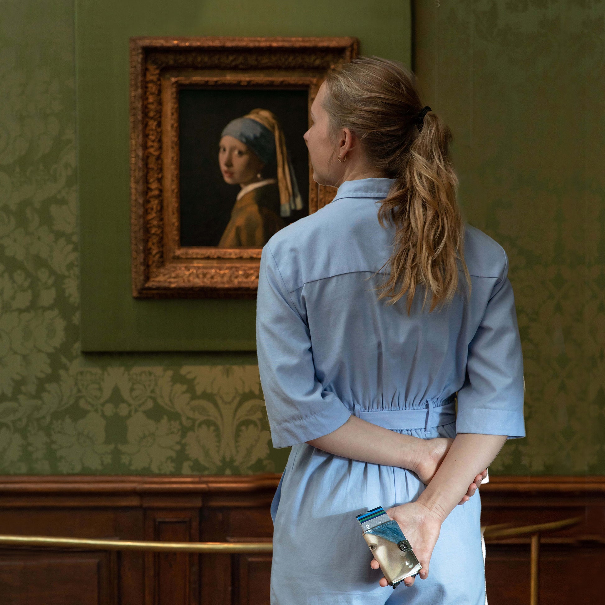 Secrid Miniwallet Art Collection Meisje met de parel│art. MAR-PEARL EARRING│Vermeer│in hand met schilderij op achtergrond
