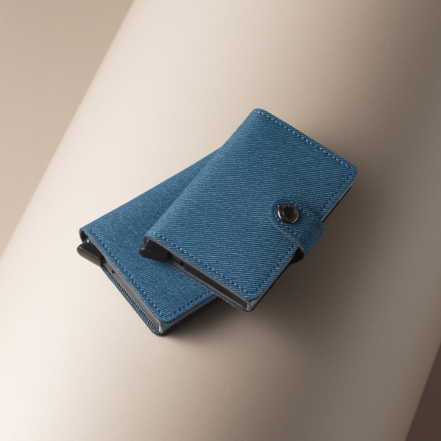 Secrid Miniwallet Twist│art. MTW-JEANS-BLUE││Pasjeshouder│bovenaanzicht met slimwallet op beige ondergrond