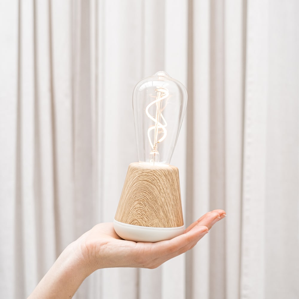 Humble One Oplaadbare tafellamp Eiken│Draadloos│Humble Lights│art. HUMTL00110│op hand voor gordijn met licht aan
