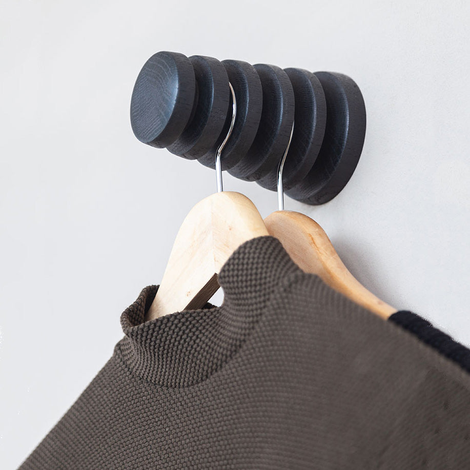 Wandhaak Alf Eiken Zwart│Vij5│Gustav Rosén│aan wand met twee houten hangers met kledingstukken