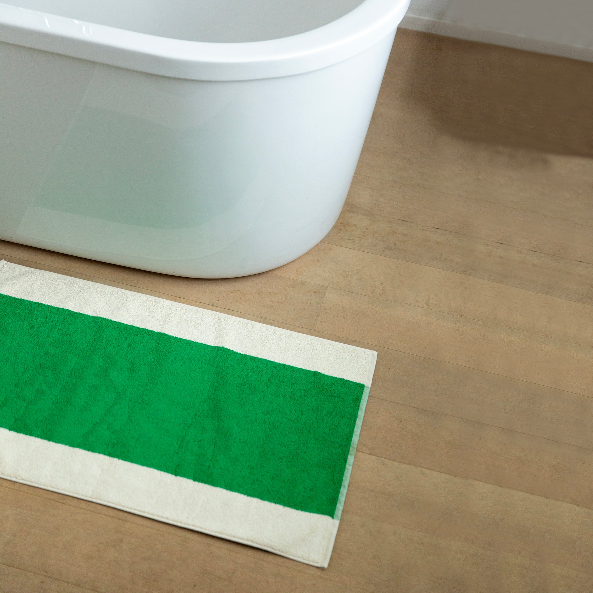 Badmat Martens & Martens Green&Honey│Suite702│art. MMBM50GRHO│op houten vloer naast badkuip