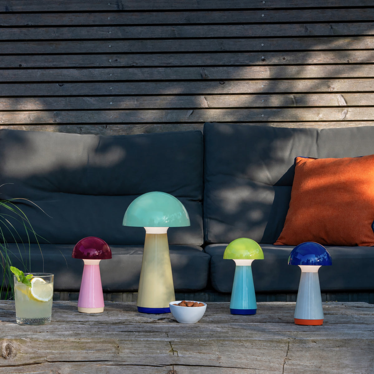 Remember Bobbi Oplaadbare LED Tafellamp | in blauw, geel en berry met Bob Mint buiten op tafel voor een loungebank