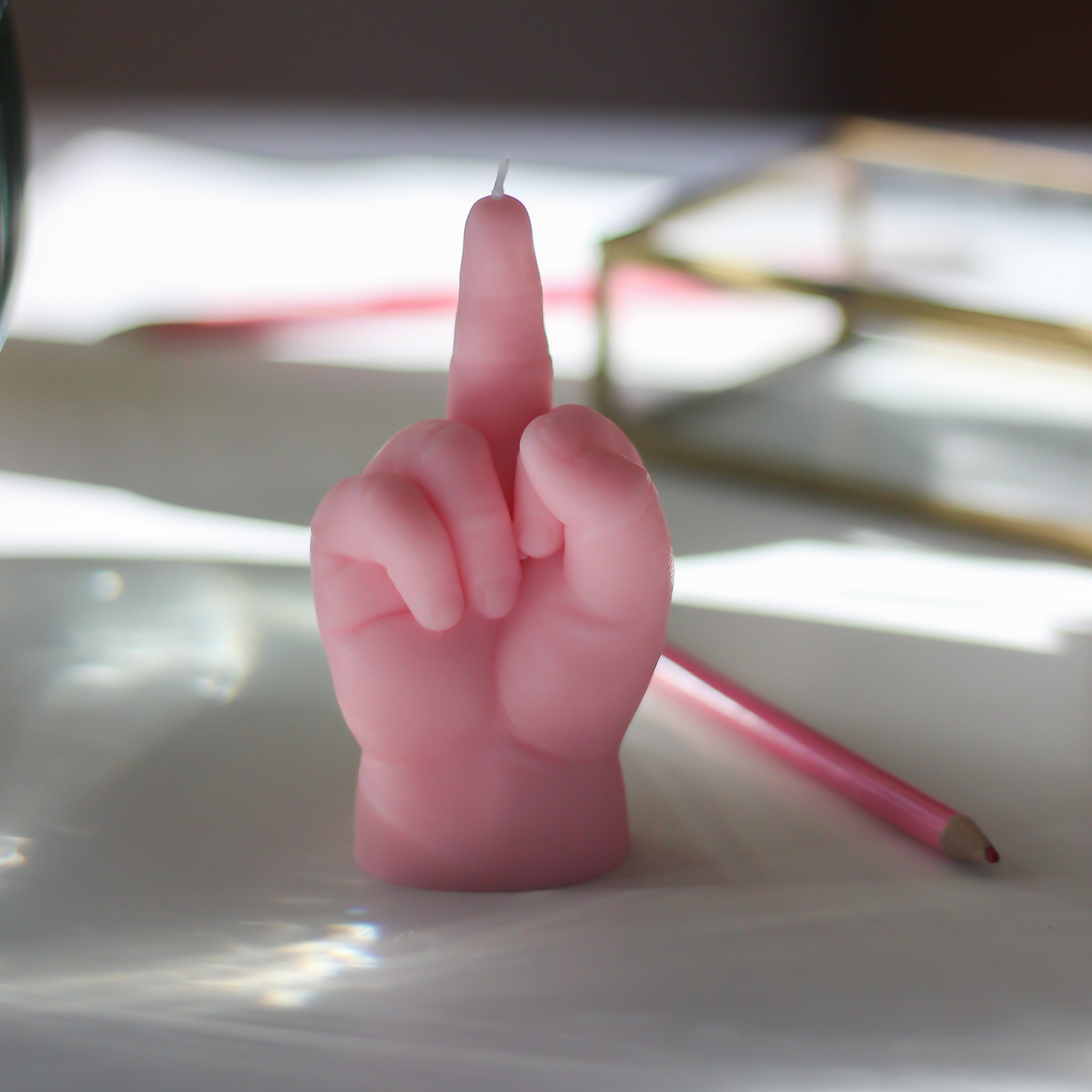 CandleHand F*ck You Kaars Baby Roze│art. BB-FCK-PINK│op tafel naast potlood