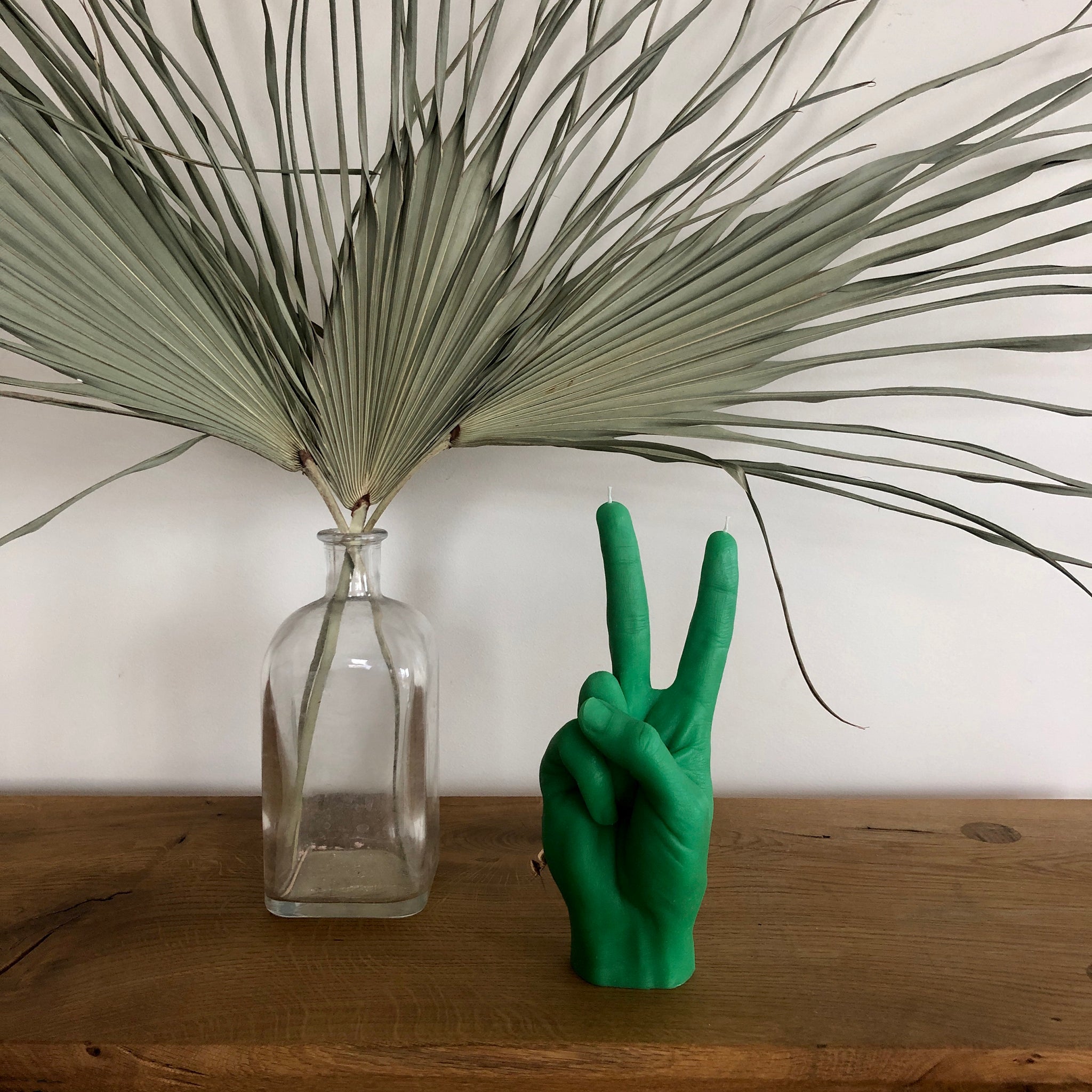 Candlehand Peace Kaars Groen│art. VIC-GREEN│op houten tafeltje naast plant