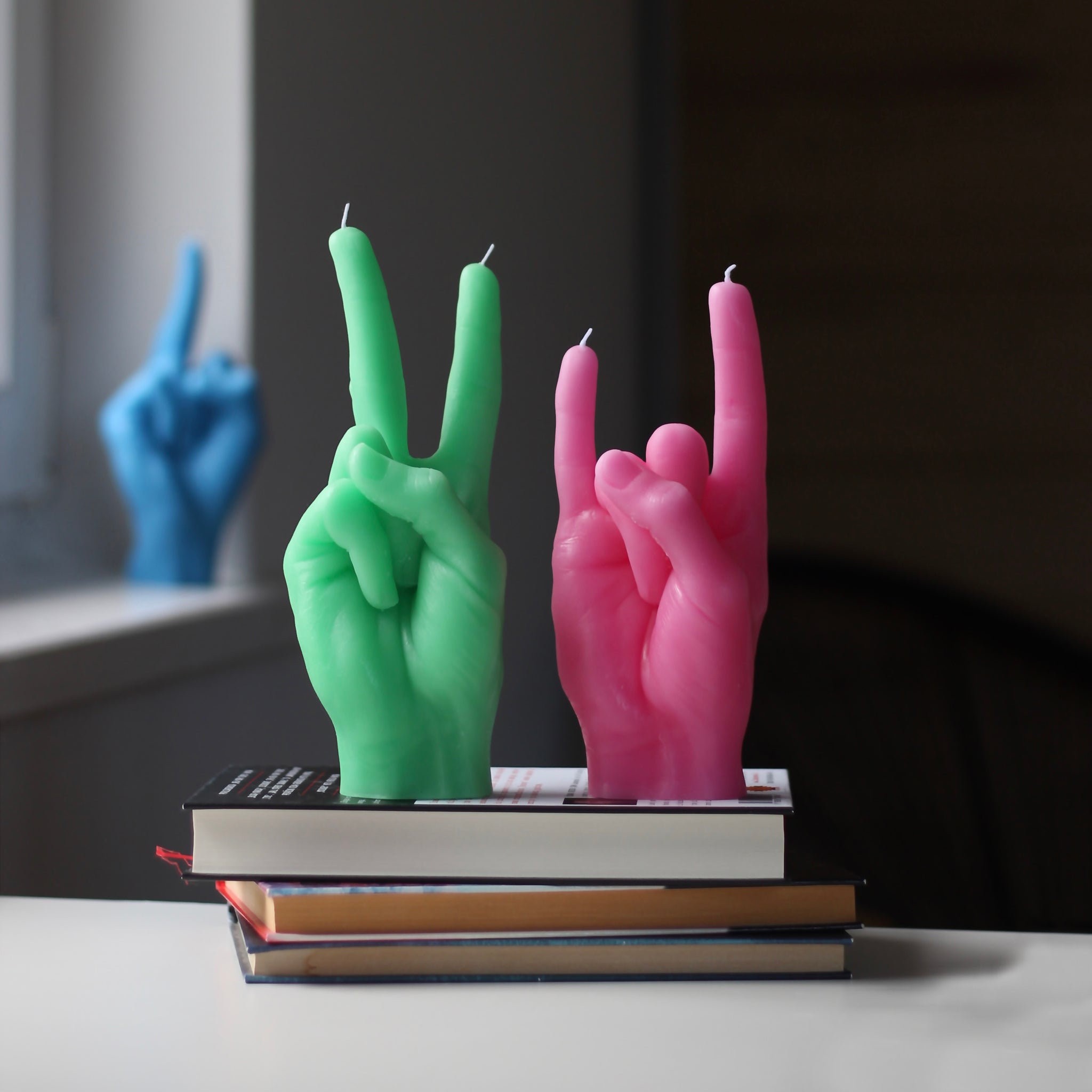 Candlehand Peace Kaars Groen│art. VIC-GREEN│naast roze You Rock versie op boeken