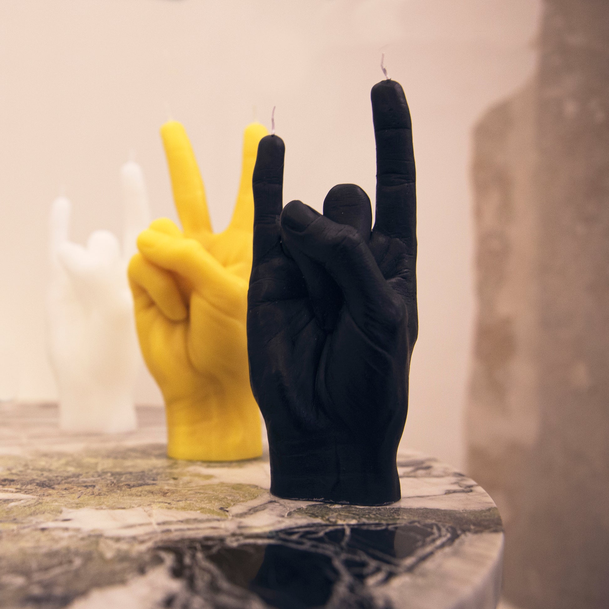 Candlehand You Rock Kaars Zwart│art. RCK-BLACK│met gele versie op marmeren tafel