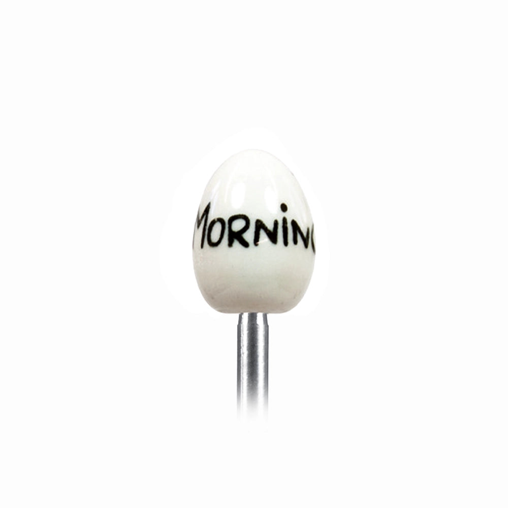 Clack egg topper with a ceramic egg reading Good Morning, close up beside a boiled egg.